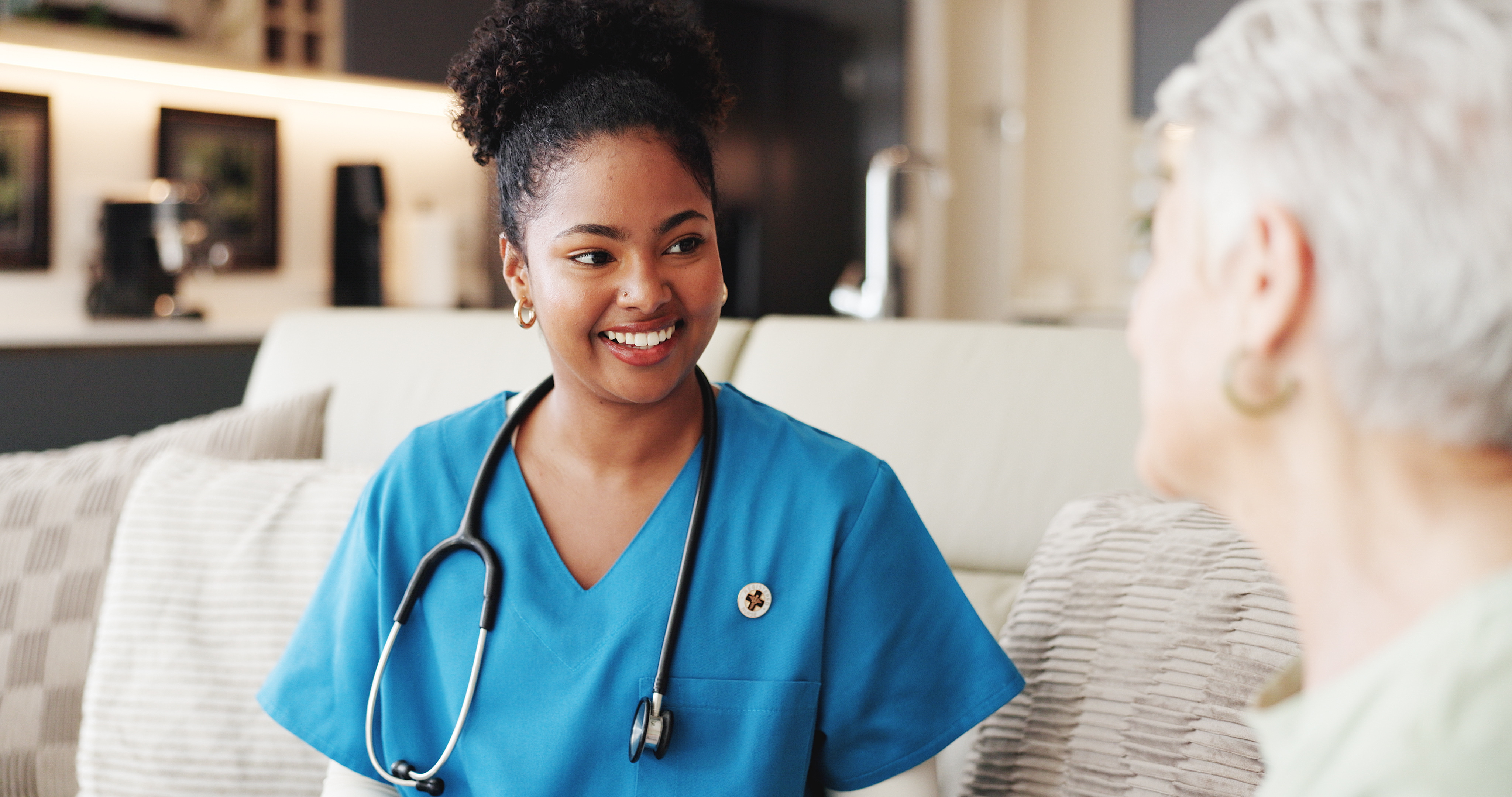 nurse-in-blue-scrubs-smiling-with-elderly-patient.jpeg