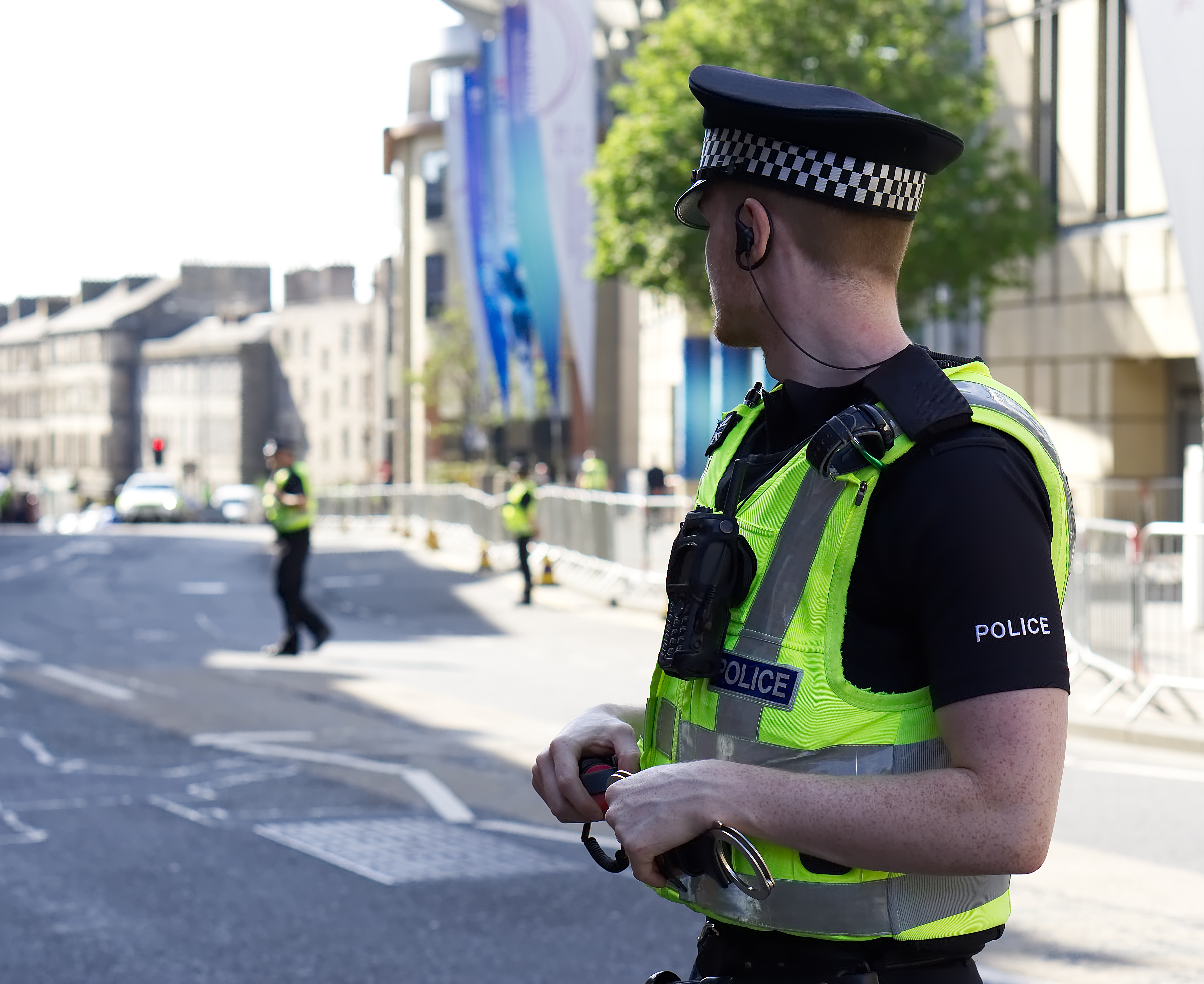police-officer-in-hi-vis-vest-standing-guard-on-city-street.jpeg